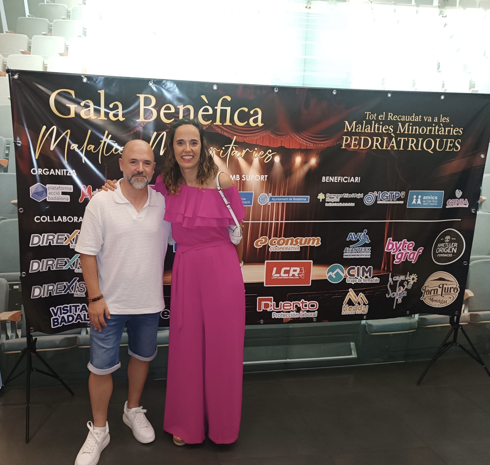 Asistentes ante el cartel de la Gala Benèfica per a les Malalties Minoritàries Pediàtriques, en Badalona